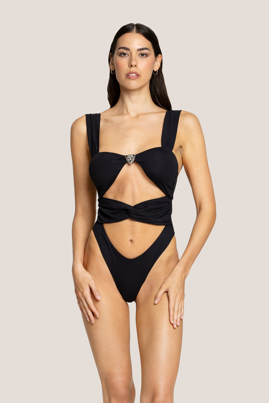 Black and metal monokini hanging on wooden chair by pool